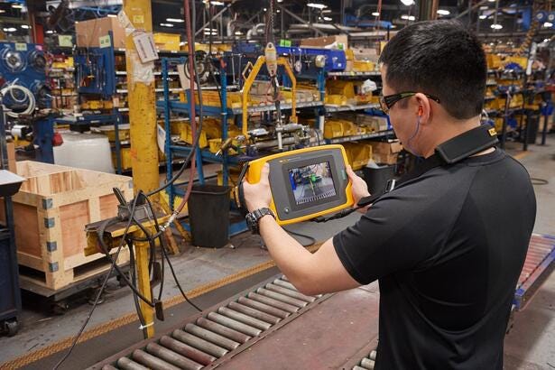 Tekniker anvender Fluke ii910 Sonic Industrial Imager til inspektion på en fabrik.