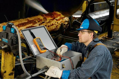 Tekniker foretager fejlfinding med Fluke 87V multimeter i et industrielt miljø.
