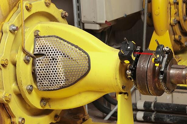 Fluke 830 magnetiske beslag monteret på en aksel til præcis laser-aksialjustering i et industrimiljø.