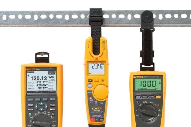 Fluke multimetre og spændingstester monteret med ToolPak universalophæng på metalskinne til måling.